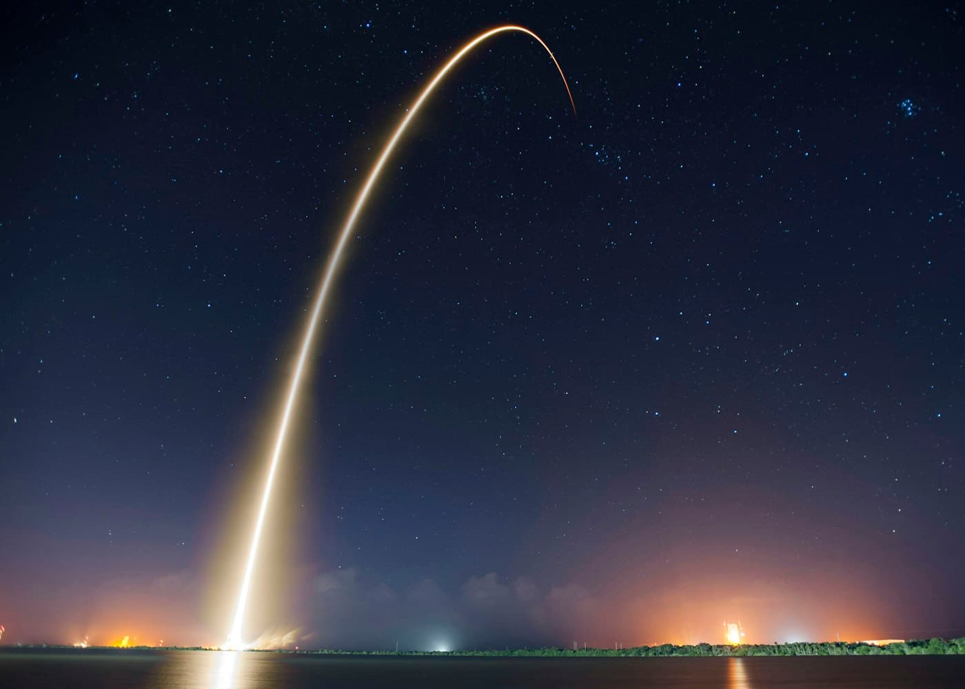 Rocket launch arcing into the night sky